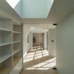 Modern finished basement with exposed brick wall and recessed lighting.