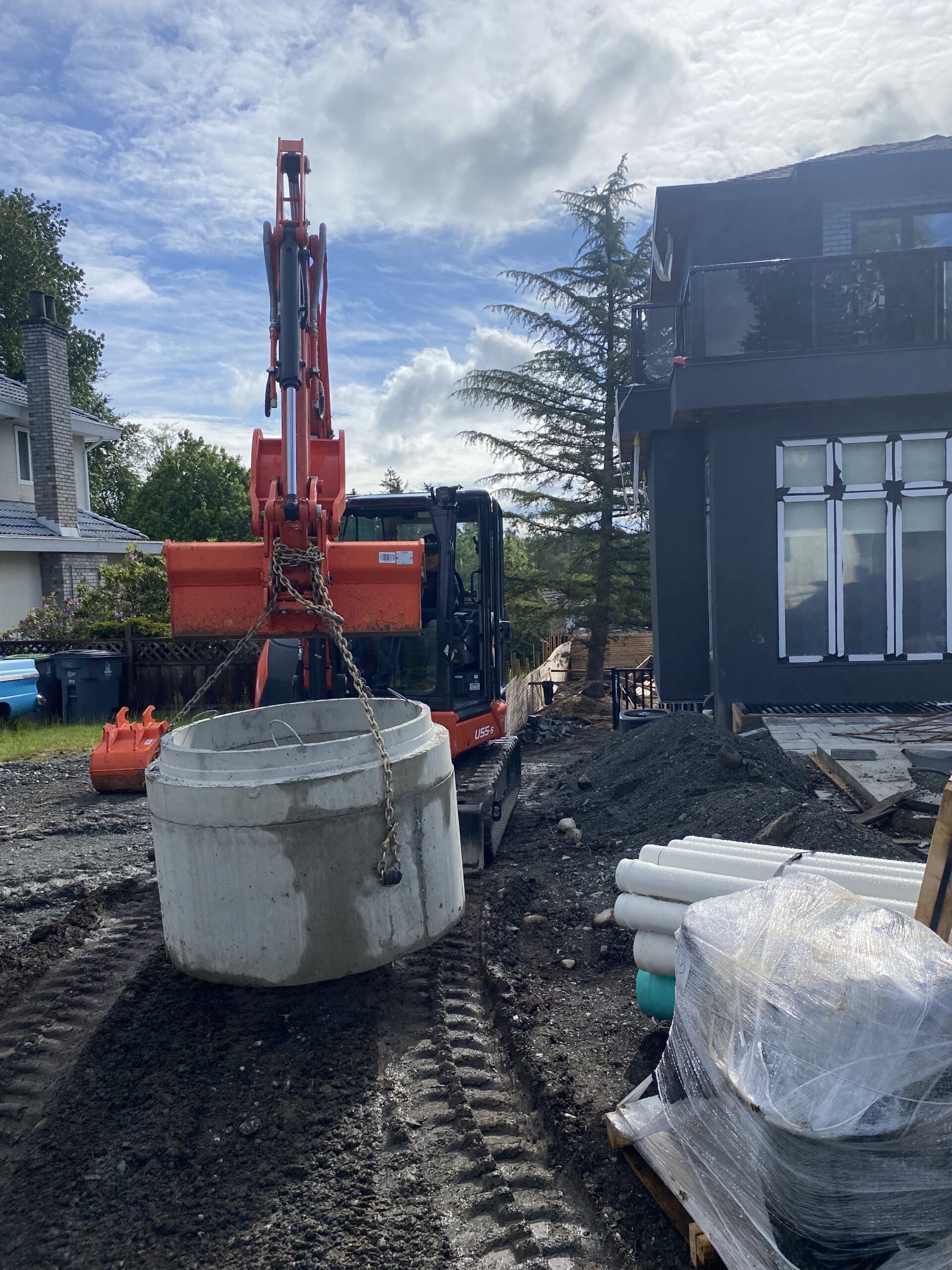 Mini excavation equipment off loading a sump basin.