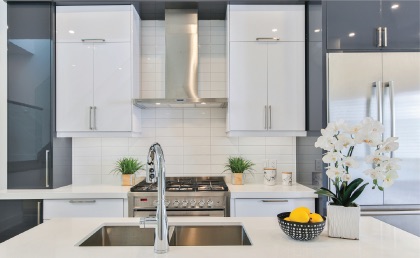 Handyman installing a modern kitchen faucet with sprayer.