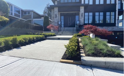 Professional hardscape installation featuring interlocking pavers, stone slabs, and a tiered retaining wall.